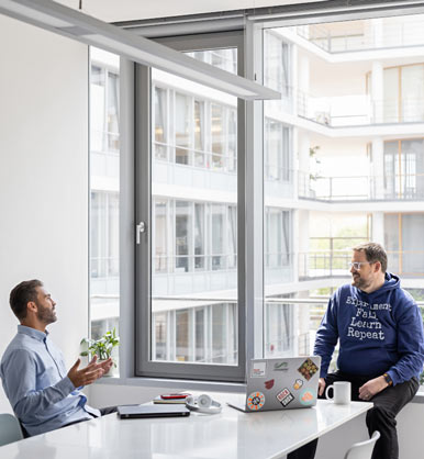 Dos empleados hablando entre sí en una oficina