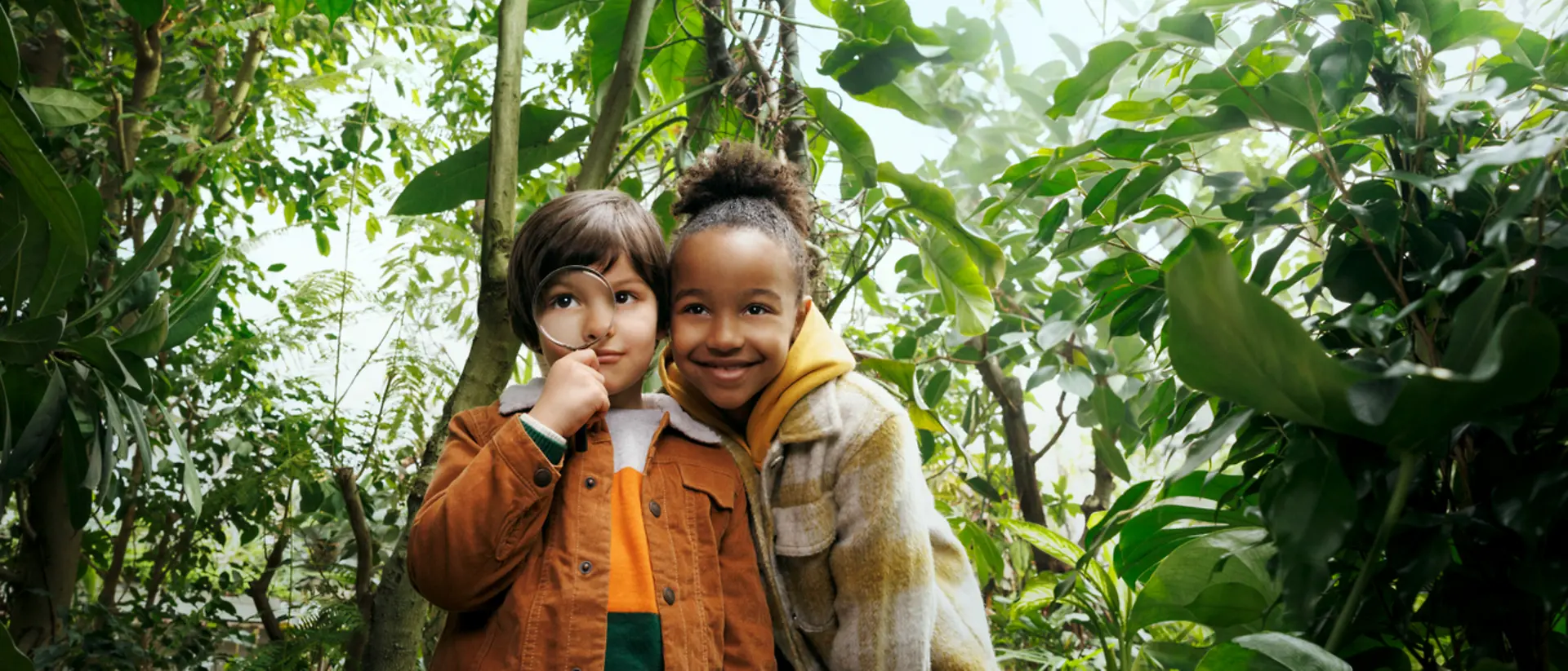 Dos niños en mitad de un bosque.