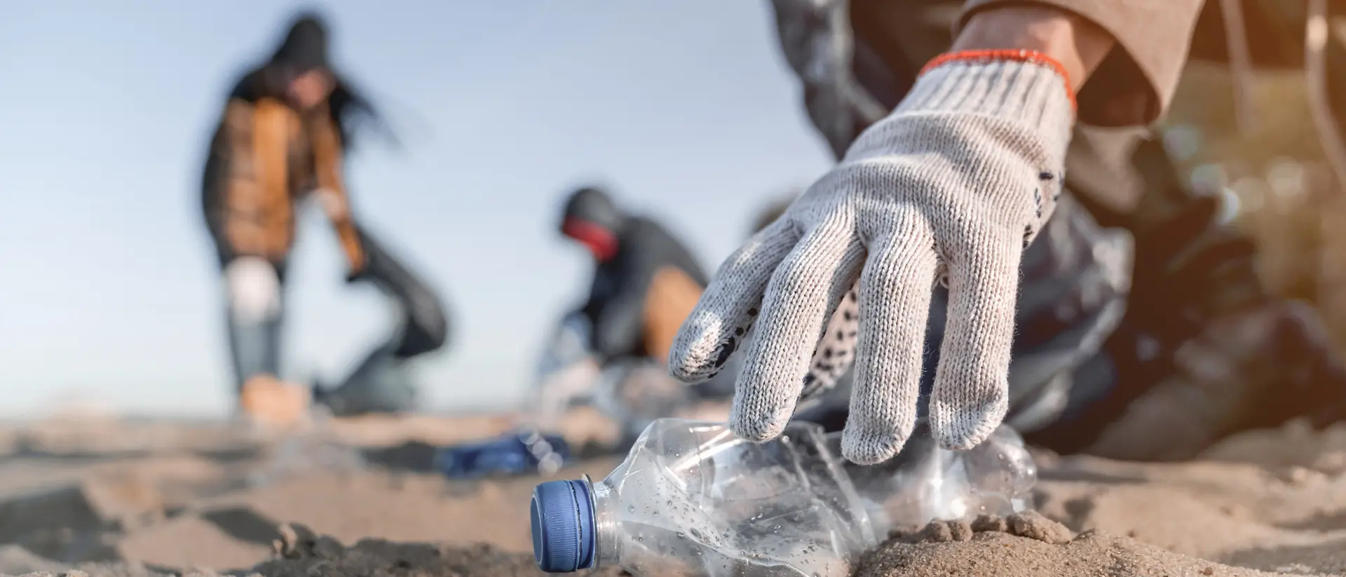 Voluntarios recogiendo basura en una playa.