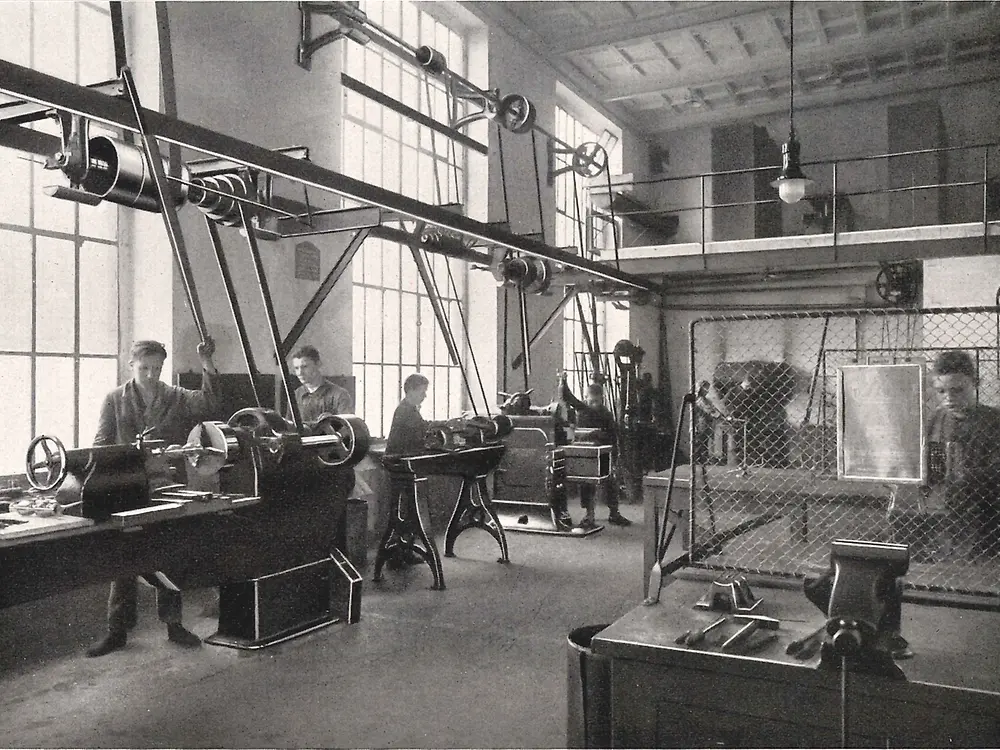 Aprendices trabajando en máquinas en el taller de metalurgia.