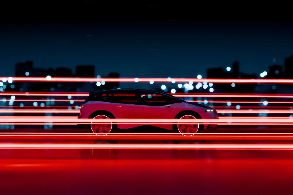 Vehículo eléctrico en carretera con efectos de luz roja que transmiten velocidad y tecnología, sobre un fondo urbano nocturno.