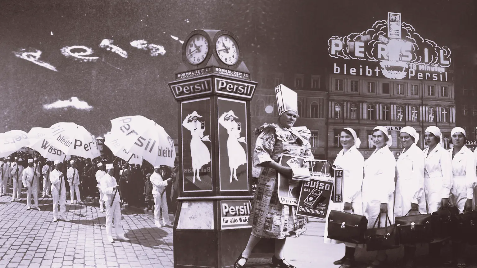 Collage publicitario vintage de Persil con personas sosteniendo paraguas de la marca, un reloj decorativo con carteles y un edificio con letrero iluminado de Persil al fondo.