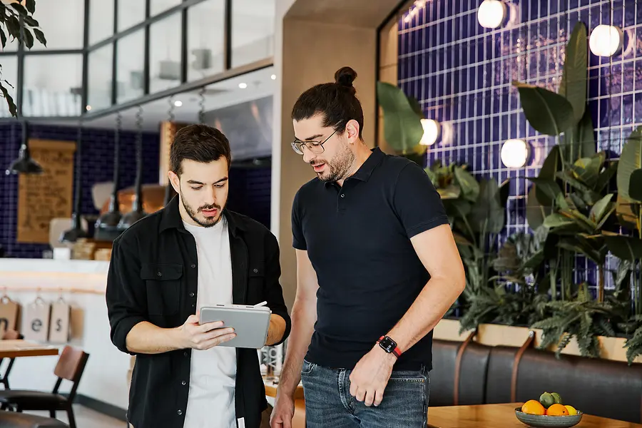 Dos compañeros trabajando juntos en un entorno de oficina relajado e informal.