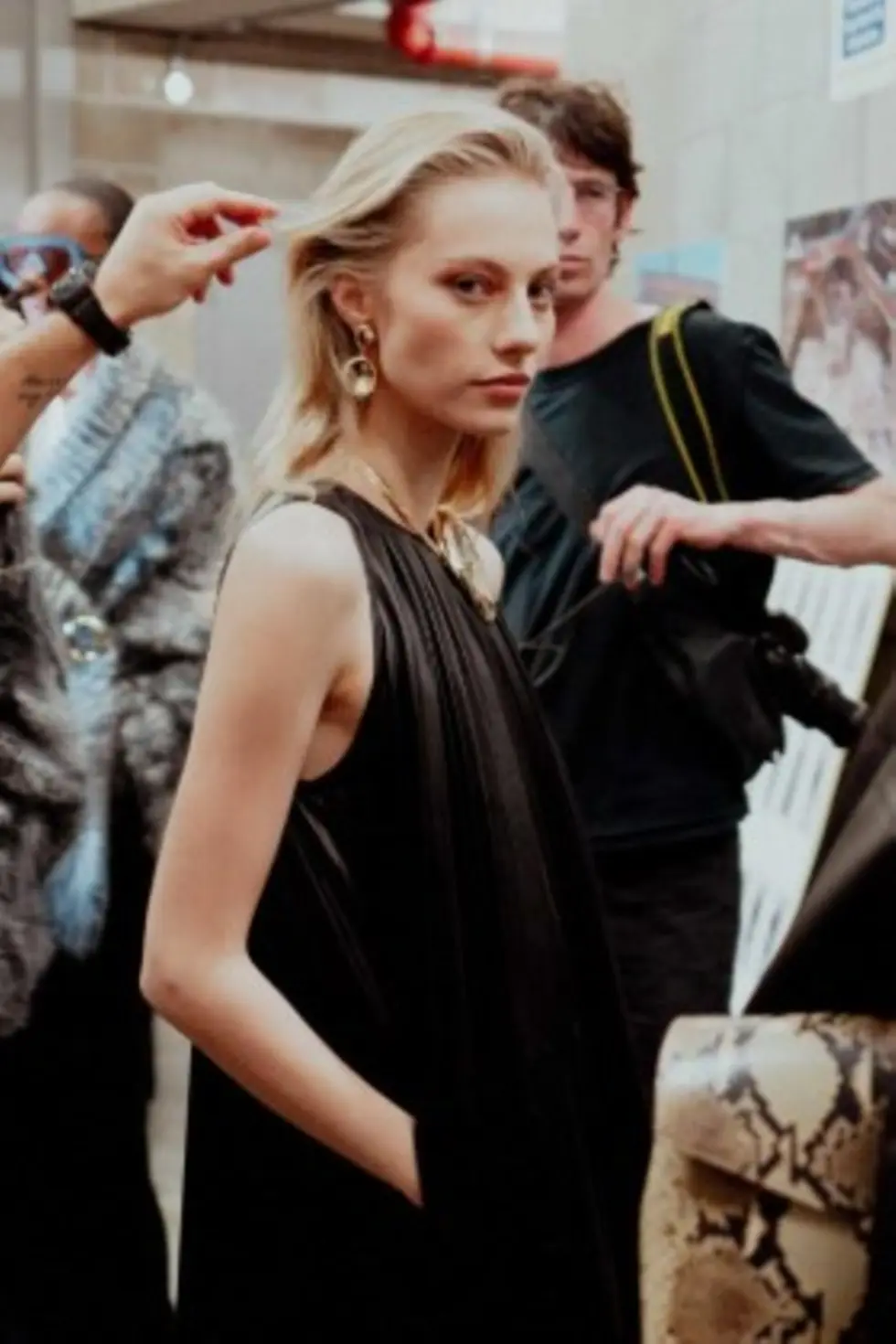 Modelo entre bastidores durante la Semana de la Moda de Londres mientras estilistas ajustan su cabello con productos de Authentic Beauty Concept.