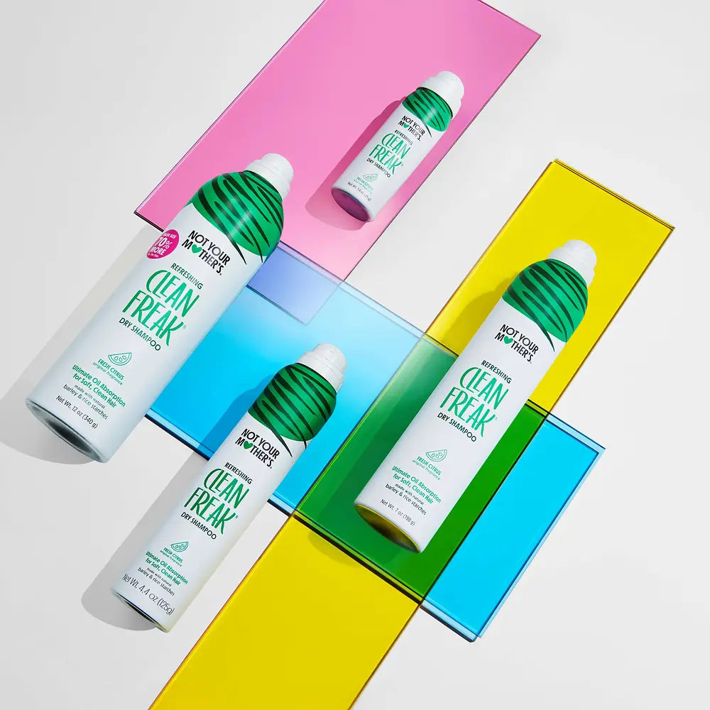 Colección Clean Freak de Not Your Mother’s con champú en seco en distintos formatos sobre un fondo de colores.