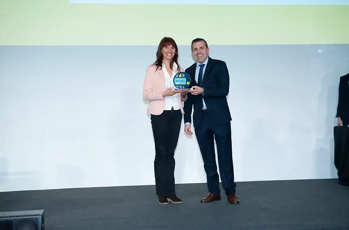 Representante de Henkel Ibérica recibiendo un premio de seguridad vial en el escenario de los Premios de Sostenibilidad de Ayvens.