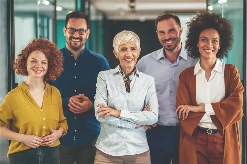 Grupo diverso de profesionales posando en una oficina, representando el objetivo de Henkel de lograr una representación equilibrada de mujeres y hombres en puestos de gestión para 2030.