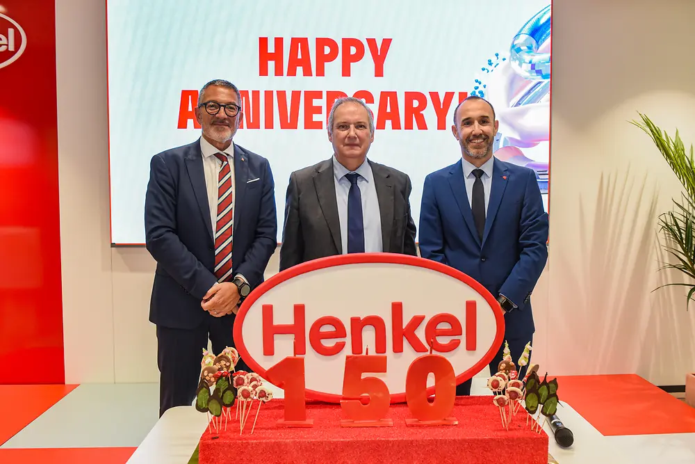Jordi Hereu, Adrian Orbea y Miquel Sàmper posan junto al logotipo de Henkel durante la celebración del 150 aniversario de la compañía en la sede de Barcelona.