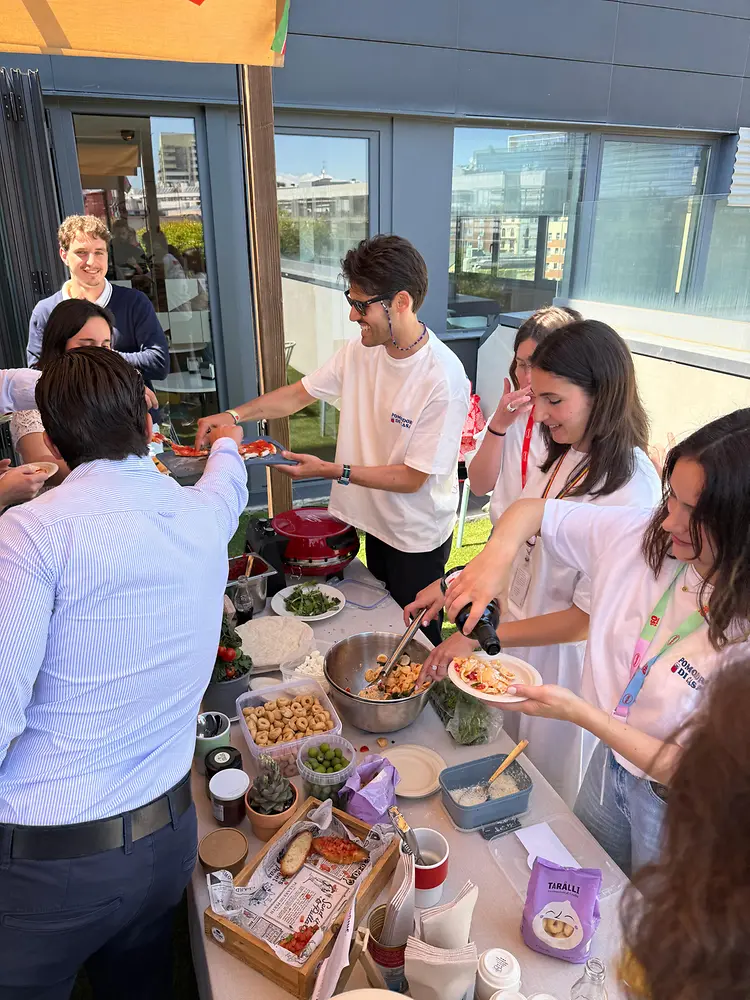 Empleados de Henkel Ibérica sirven platos internacionales durante una jornada de diversidad cultural en Barcelona.