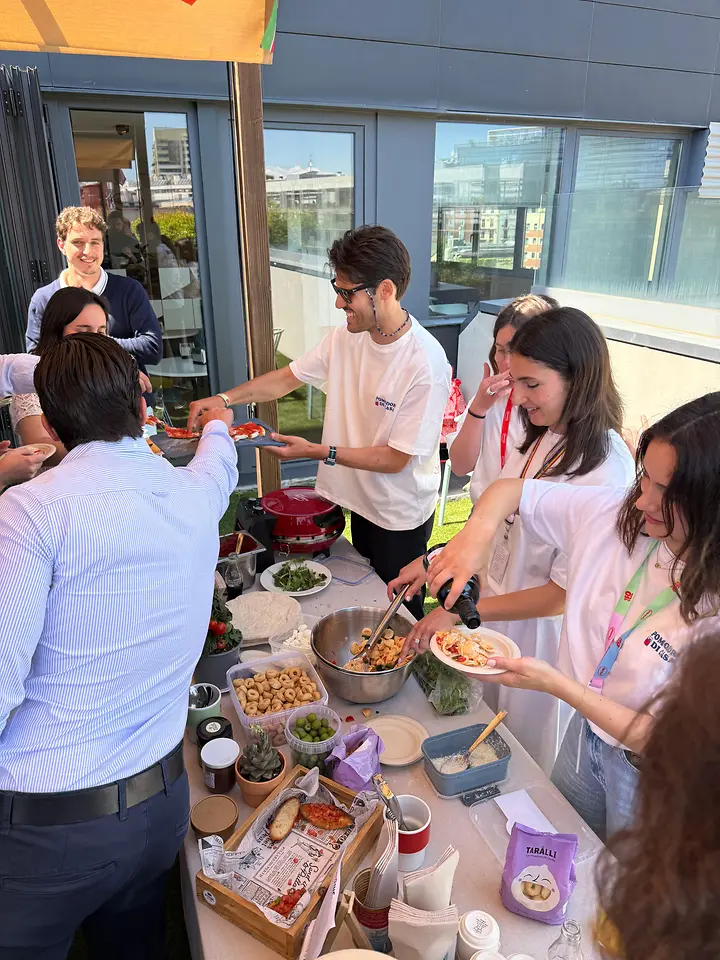 Empleados de Henkel Ibérica sirven platos internacionales durante una jornada de diversidad cultural en Barcelona.