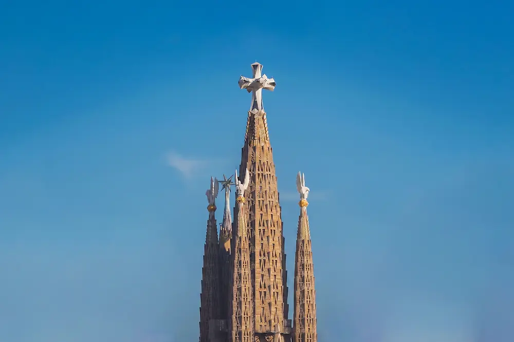 Torre de Jesucristo de la Sagrada Familia contra el cielo azul de Barcelona