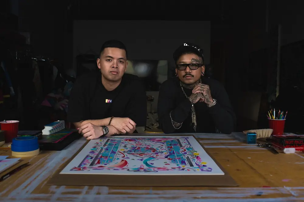 Louis De Guzman y un colaborador posan junto a una obra artística de la STMNT Artist Edition 2026.