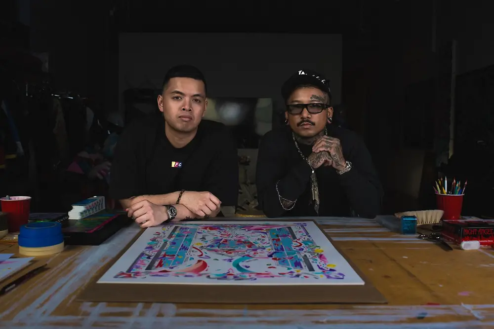 Louis De Guzman y un colaborador posan junto a una obra artística de la STMNT Artist Edition 2026.