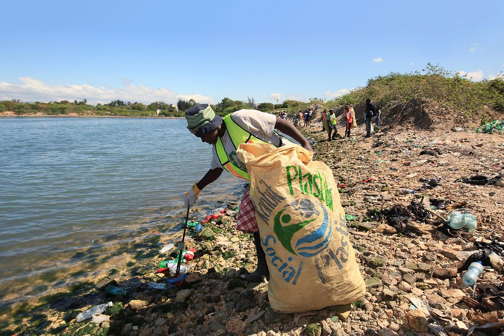 Mujeres recogiendo residuos plásticos en la playa.