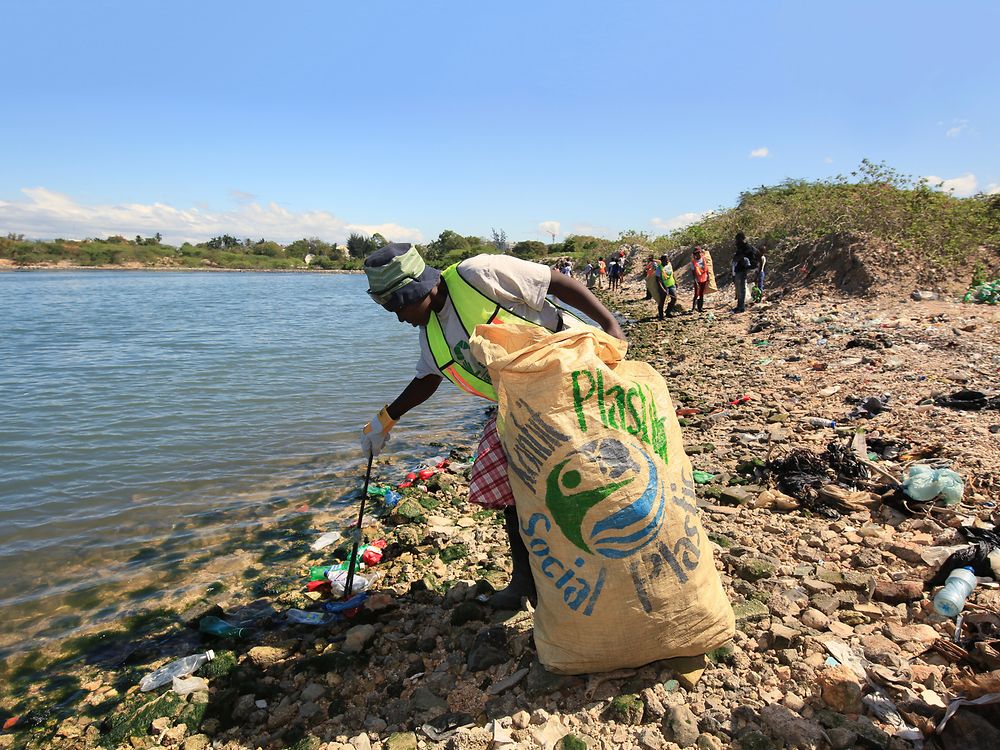 Mujeres recogiendo residuos plásticos en la playa.
